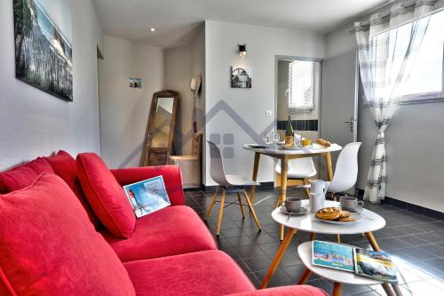 un salon avec un canapé rouge et une table dans l'établissement LocaLise - C80 - L'escale - Au 1er étage de plain pied - Wifi inclus - Draps inclus - Animaux bienvenus, au Guilvinec
