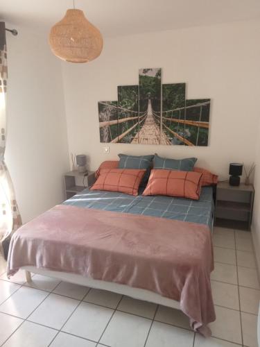 une chambre avec un grand lit avec des oreillers orange dans l'établissement La Casa de Jennifer, à Aillac