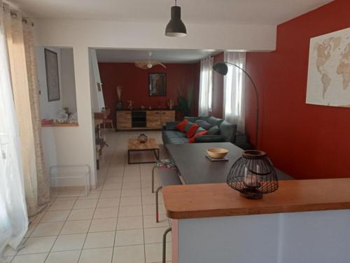 Il comprend une cuisine et un salon avec des murs rouges et une table. dans l'établissement La Casa de Jennifer, à Aillac