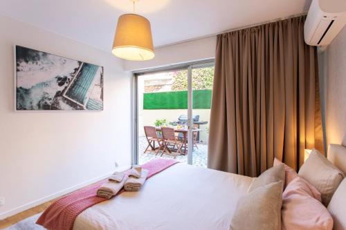 une chambre avec un lit et une grande fenêtre dans l'établissement 86m- Spacious 3 room apartment with large terrace, à Villefranche-sur-Mer