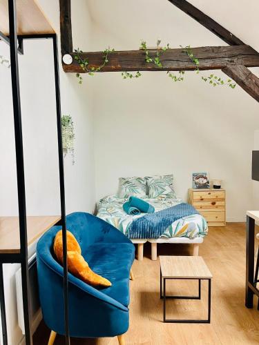 Cette chambre comprend une chaise bleue et un lit. dans l'établissement Le Nid Suspendu, à Orléans