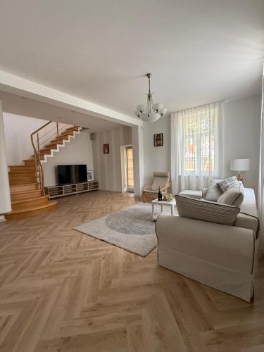 a living room with a couch and a staircase at Amber Coast & Sea in Jūrmala
