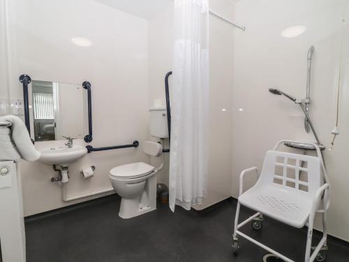 a bathroom with a white toilet and a sink at Harcombe House Accessible Pet Free Bungalow Sleeps 6 in Newton Abbot