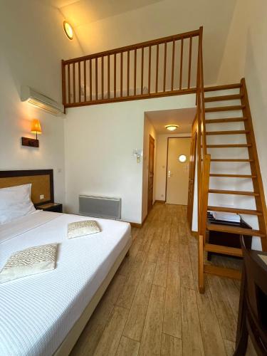 a bedroom with a large bed and a staircase at Ma Campagne in Saint-Rémy