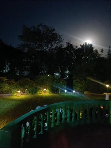 a night view of a yard with a fence at the Kutumb- Where the Himalayas come alive! in Pālampur