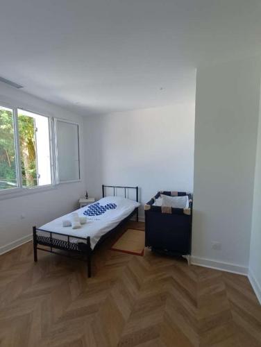 une chambre blanche avec un lit et une fenêtre dans l'établissement Maison familiale aux portes de Périgueux, à Coulounieix-Chamiers