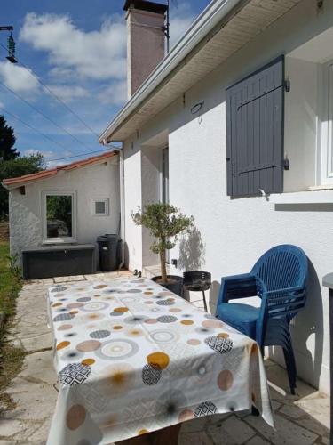 une table et des chaises assises sur une terrasse dans l'établissement Maison familiale aux portes de Périgueux, à Coulounieix-Chamiers