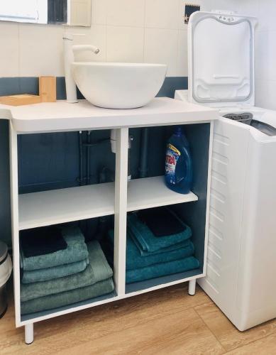 un comptoir de salle de bain blanc avec un lavabo et des serviettes dans l'établissement le Pouliguen centre ville, au Pouliguen