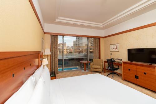 a hotel room with a bed and a flat screen tv at Holiday Inn Kuwait by IHG in Kuwait