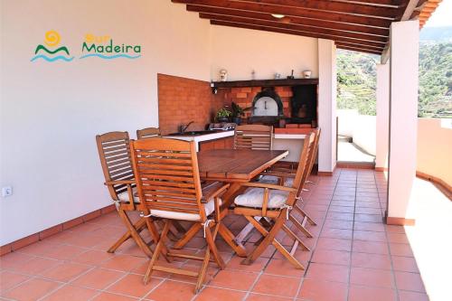a dining room with a wooden table and chairs at OurMadeira - Casa do Júlio in Calheta