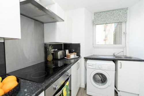 a kitchen with a washing machine and a washer and dryer at Studio flat in Dundee in Dundee