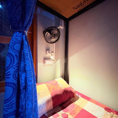 a bedroom with a bed and a window and a fan at Sangita Homestay in Siliguri