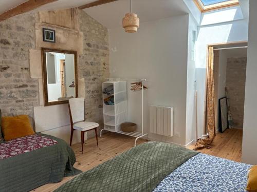 une chambre avec un lit et une chaise dedans dans l'établissement Le Cottage, à Foussignac