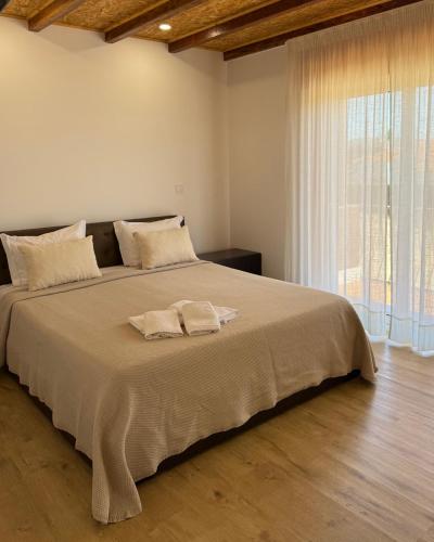 a bedroom with a large bed with a large window at Guest House MJ in Póvoa de Varzim
