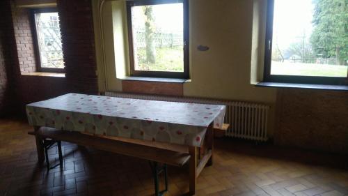 einen Tisch in einem Zimmer mit zwei Fenstern in der Unterkunft Haus Vinzenz Amel in Amel
