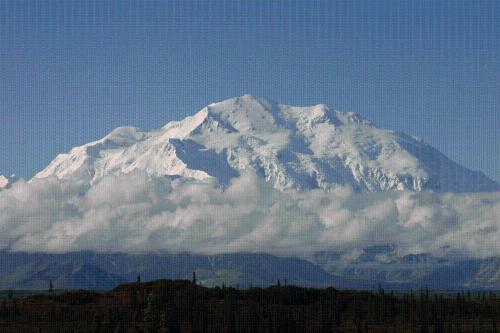 a snow covered mountain with clouds in front of it at McKinley Creekside Cabins in McKinley Park