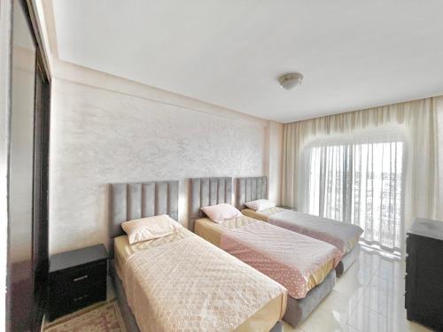 two beds in a hotel room with a television at Family Home -2 in Agadir