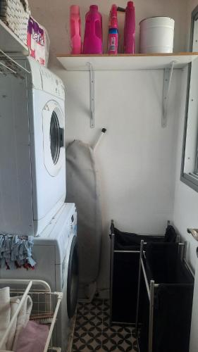 a washer and dryer in a kitchen with a shelf at דירה מעוצבת עם נוף מדהים לים in H̱adera