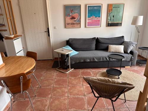 un salon avec un canapé et une table dans l'établissement Charmante maison de pêcheur, à Aigues-Mortes