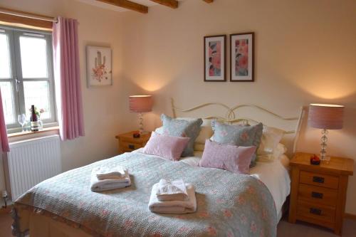 a bedroom with a bed with towels on it at Hawthorn Cottage Luxury stone Built Cottage in Tregoney