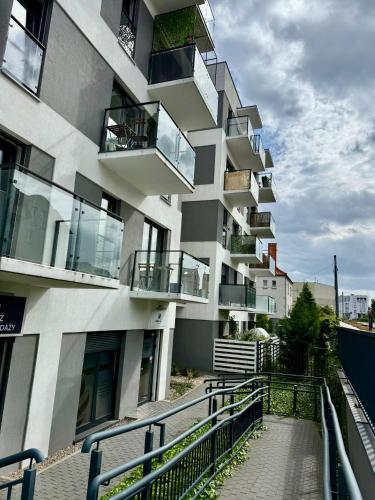 a building with balconies and a walkway in front of it at Just Unique black in Poznań