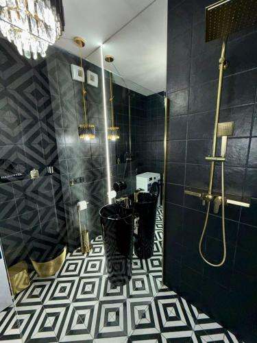 a bathroom with a black and white tiled floor at Just Unique black in Poznań