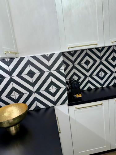 a kitchen with black and white tiles on the wall at Just Unique black in Poznań