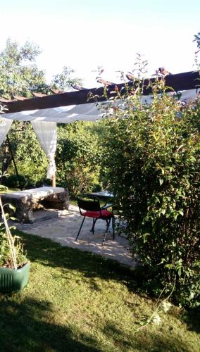 a picnic table under a white canopy in a garden at Diamat in Ivišovo Greblje