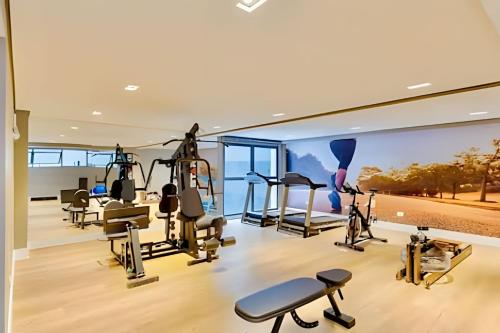 a gym with treadmills and exercise equipment in a house at REFUGiO Studio novo c/cama Queen e Ar Condicionado in Curitiba