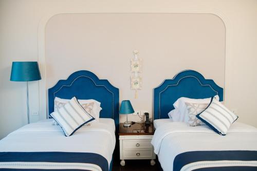 two beds in a room with blue headboards at Nile Transportation hotel in Cairo
