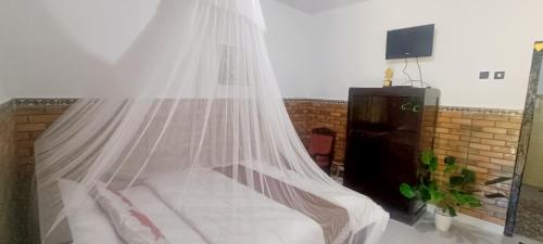 a bedroom with a bed with a mosquito net at Gosela Bali in Munduk