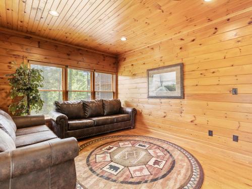 a living room with leather couches and a rug at The Great Escape II, 5 Bedrooms, Sleeps 17, Game Room, Pool Access, Theater in Gatlinburg