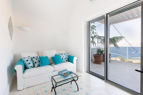 a living room with a white couch and a balcony at Casa Michela by Elite Villas in Capri
