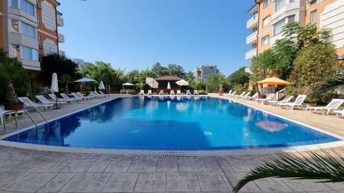 een groot zwembad in een hotel met stoelen en tafels bij Sea Diamond 2 in Sunny Beach