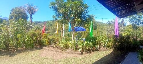 a garden with colorful flags hanging from trees at Gosela Bali in Munduk