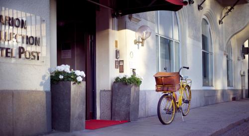 a bike with a basket parked outside of a building at Clarion Collection Hotel Post in Oskarshamn