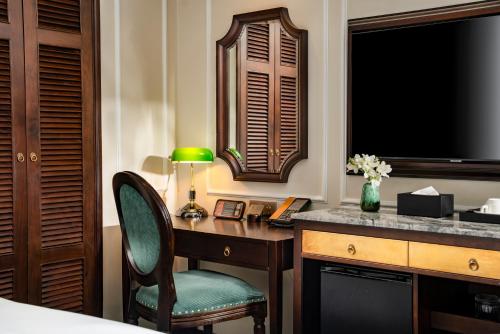 a bedroom with a desk with a lamp and a television at GM Premium Hotel in Hanoi
