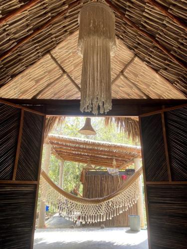 a chandelier hanging from the ceiling of a hut at Pal Mar our beach house 