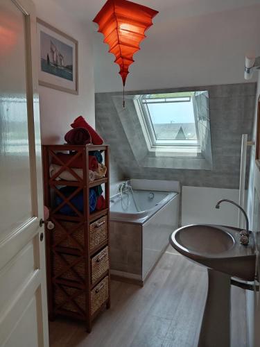 La salle de bains est pourvue d'un lavabo, d'une baignoire et d'une fenêtre. dans l'établissement La Blancherie, à Bricqueville-sur-Mer