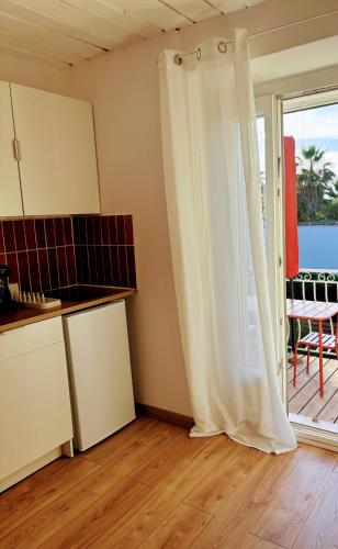 Cette chambre dispose d'une cuisine avec une porte coulissante en verre. dans l'établissement Le Nid des Salins - Studio Mer & Terrasse, à Hyères