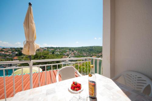 a table with a bottle of beer and a bowl of fruit on a balcony at Apartment Agata in Splitska