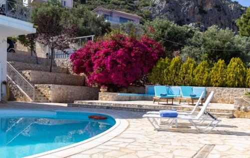 Villa con piscina con sillas y flores en InstaView Tolo 2, en Tolo