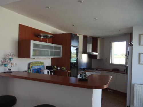 une cuisine avec des armoires en bois et un comptoir dans l'établissement A coté des plages et des marais salants de Guérande, à Guérande