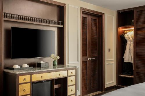 a bedroom with a flat screen tv and a dresser with a television at GM Premium Hotel in Hanoi