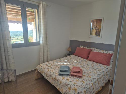 sypialnia z łóżkiem i dwoma ręcznikami na nim w obiekcie Charmant petit logement à 3 kms de la plage w mieście Belgodère