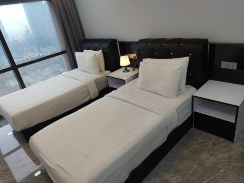a hotel room with two beds and a window at My Service Suites Times Square KL in Kuala Lumpur