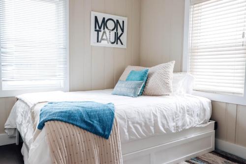 a bedroom with a bed with blue pillows on it at The Montauk Soundview in Montauk