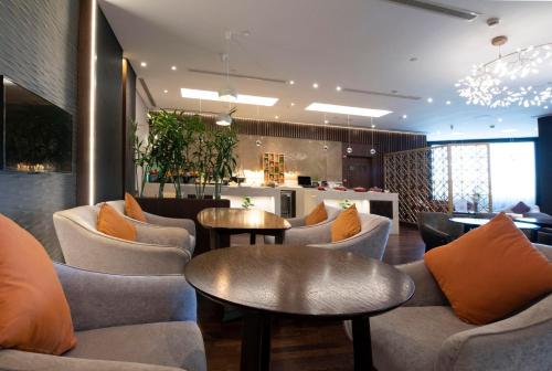a lobby with couches and tables and a kitchen at Crowne Plaza Bahrain by IHG in Manama