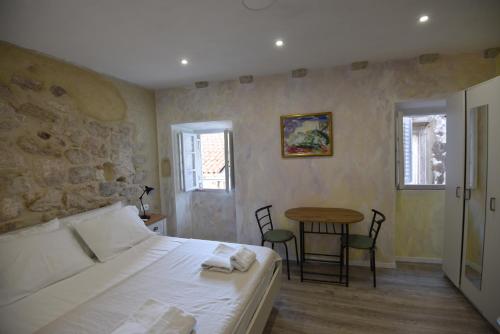 a bedroom with a bed and a table with chairs at Lorenzo Old Town in Dubrovnik