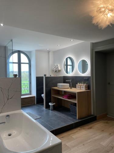 un ampio bagno con vasca e lavandino di Chateau aux portes du circuit des 24h a Yvré-lʼÉvêque